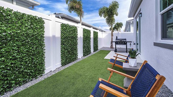 Yardly Artisan Lakes Homes: Cozy patio with stylish outdoor seating and lush greenery, perfect for relaxation