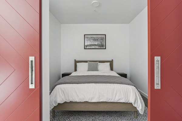 Cozy bedroom with large windows at The Marek South Apartments