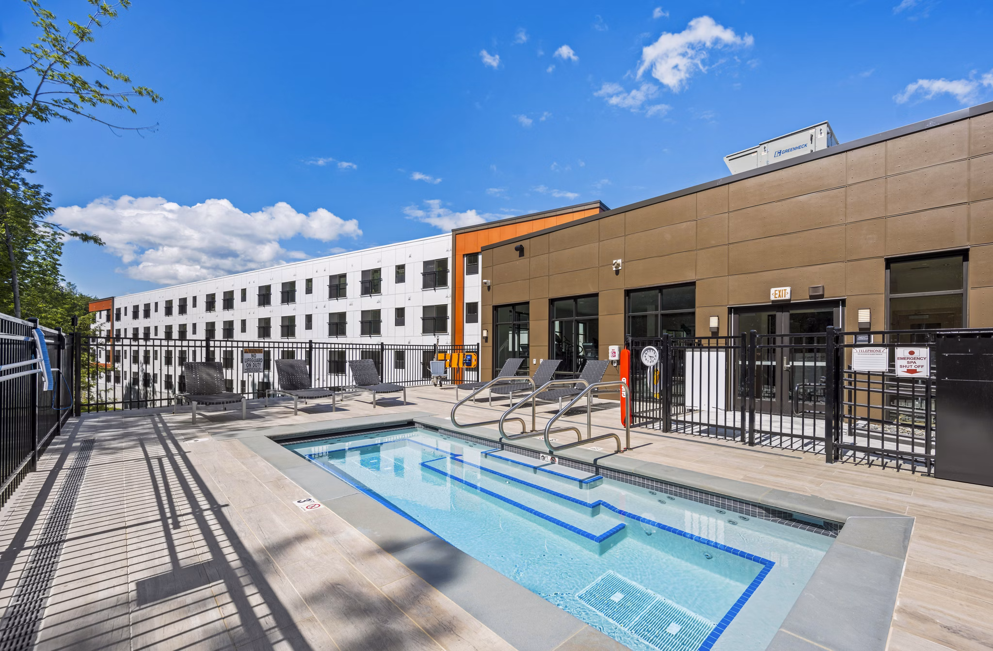 Infinity-edge pool with poolside lounging at The Marek South Apartments
