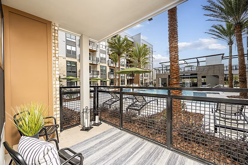 Modern patio balcony with outdoor furniture at The Aston at Town Center Apartments, offering luxury living in a vibrant community