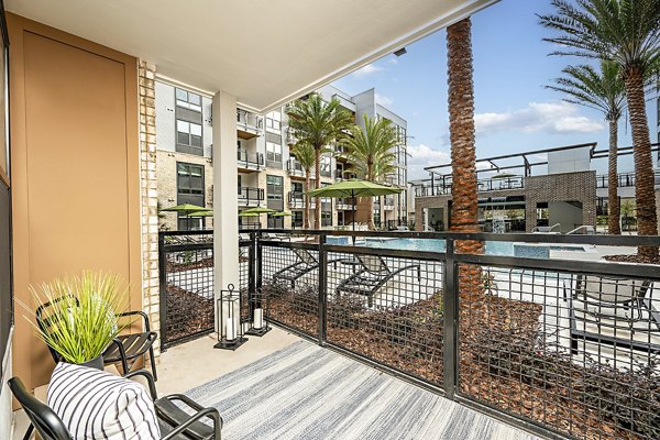 Modern patio balcony with outdoor furniture at The Aston at Town Center Apartments, offering luxury living in a vibrant community