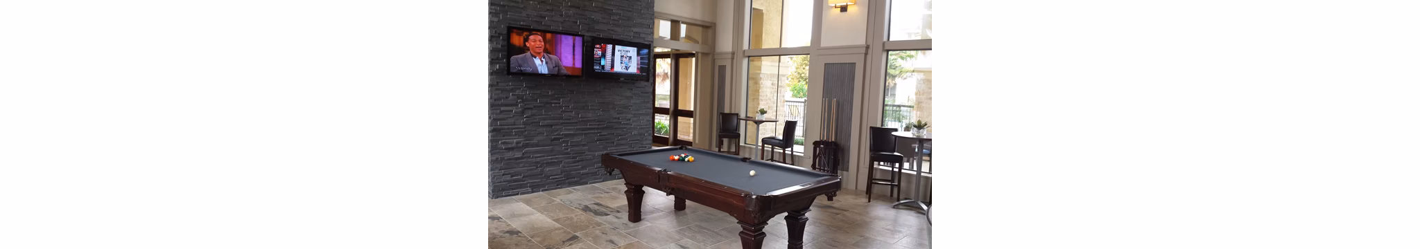 Game room with pool table and lounge seating at Palms at Cinco Ranch Apartments, offering recreational space for residents