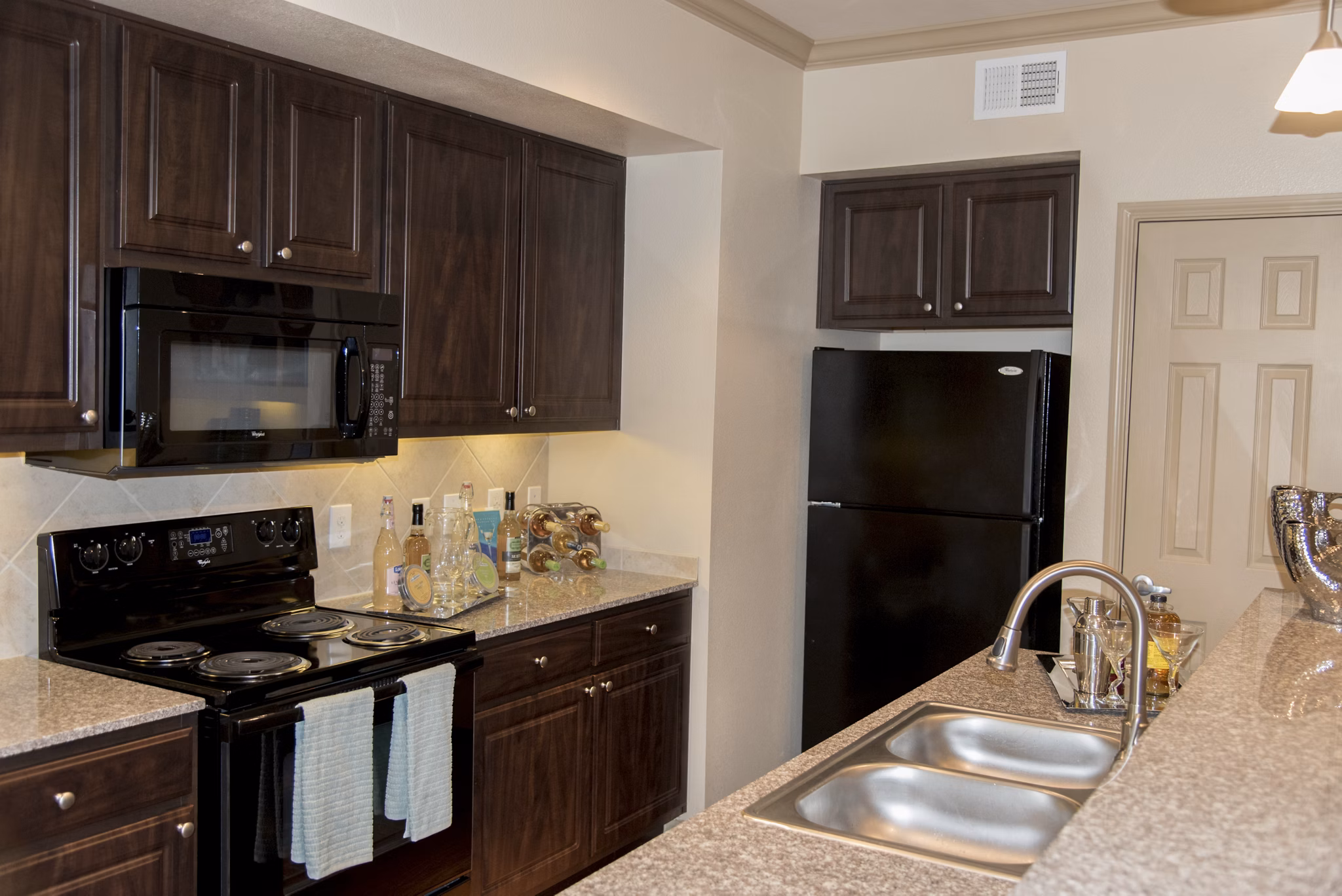Modern kitchen with stainless steel appliances and granite countertops at Palms at Cinco Ranch Apartments