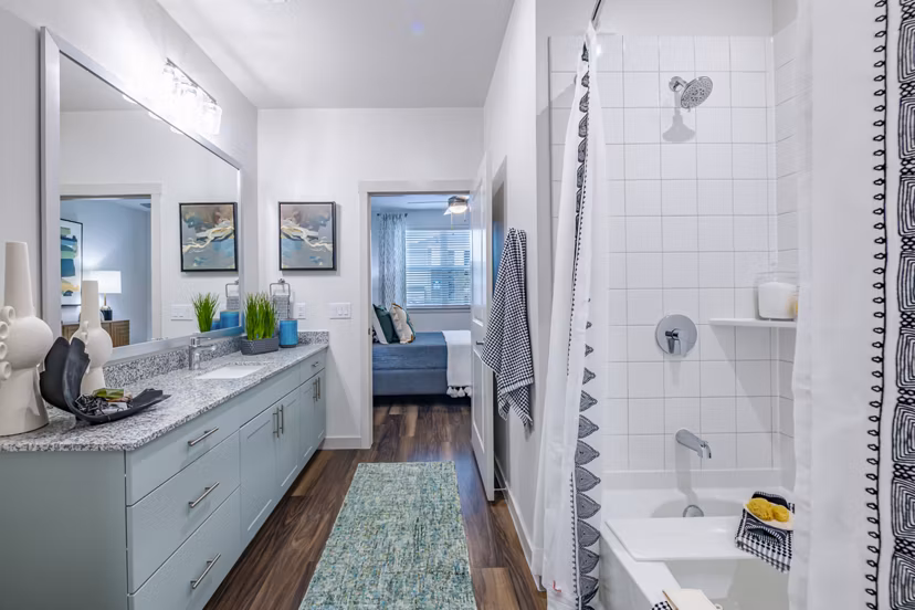 Modern bathroom featuring sleek fixtures and large mirror at Prose Stoneridge Apartments
