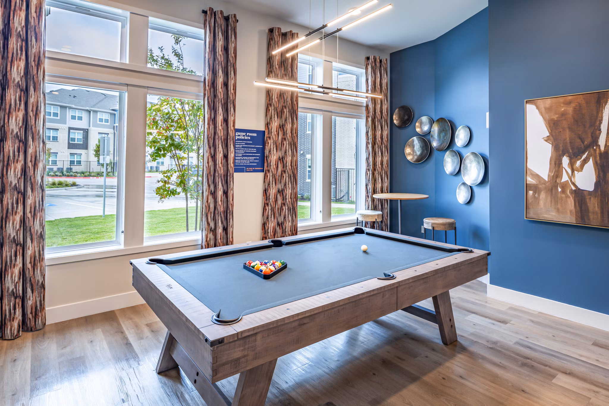 Clubhouse game room with billiards and lounge seating at Prose Stoneridge Apartments