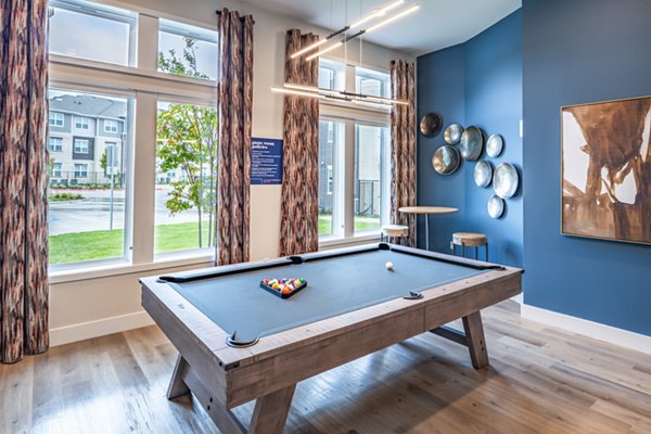 Clubhouse game room with billiards and lounge seating at Prose Stoneridge Apartments