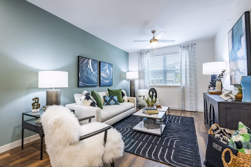 Spacious living room with modern decor and large windows at Prose Stoneridge Apartments