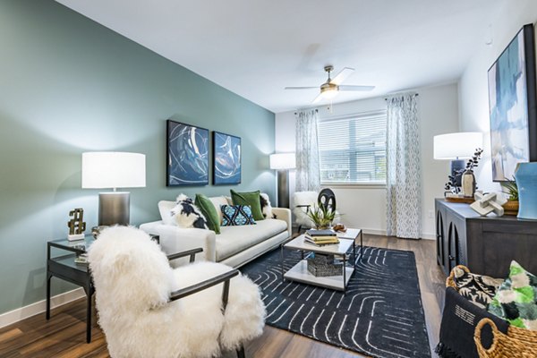 Spacious living room with modern decor and large windows at Prose Stoneridge Apartments