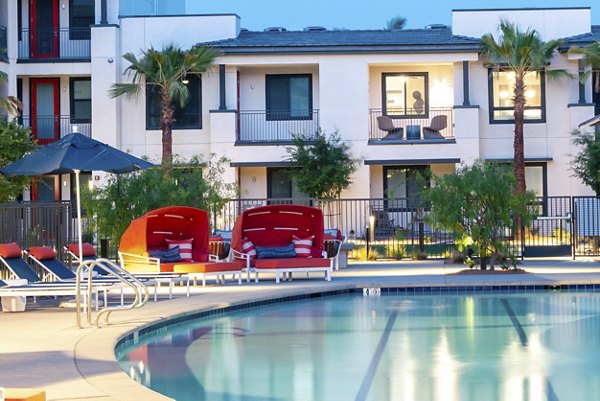 Poolside oasis at Avenida Palm Desert Apartments with palm trees and lounge chairs for a relaxing luxury living experience