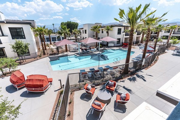 Poolside oasis with sun loungers at Avenida Palm Desert Apartments, offering a relaxing luxury living experience
