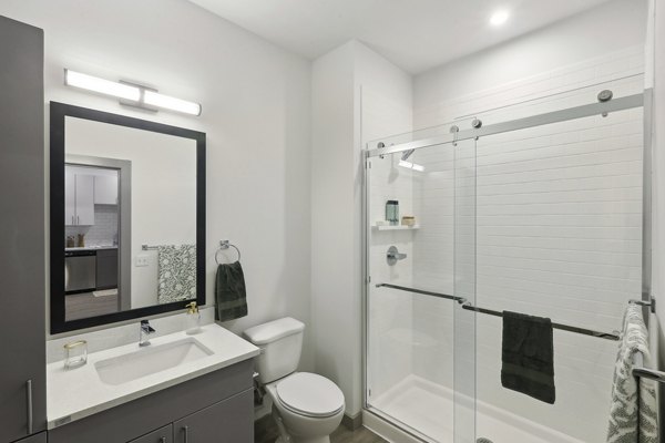Modern bathroom with sleek finishes at The Foundmore Apartments, featuring elegant vanity and spacious shower