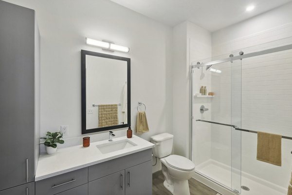Bathroom featuring sleek fixtures and modern design at The Foundmore Apartments
