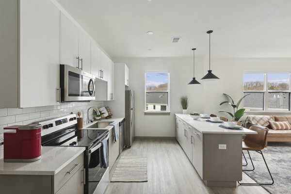 Modern kitchen with stainless steel appliances in The Foundmore Apartments, luxury living by Greystar