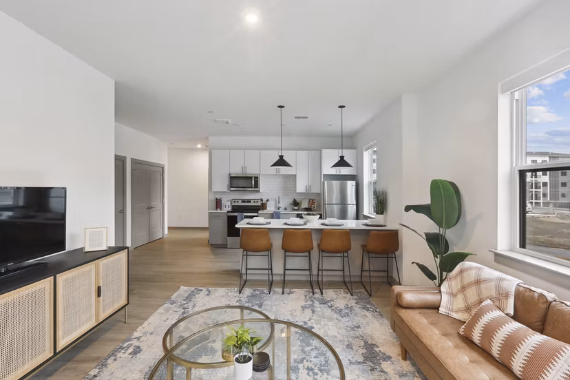 Cozy living room with stylish decor and a large window at The Foundmore Apartments