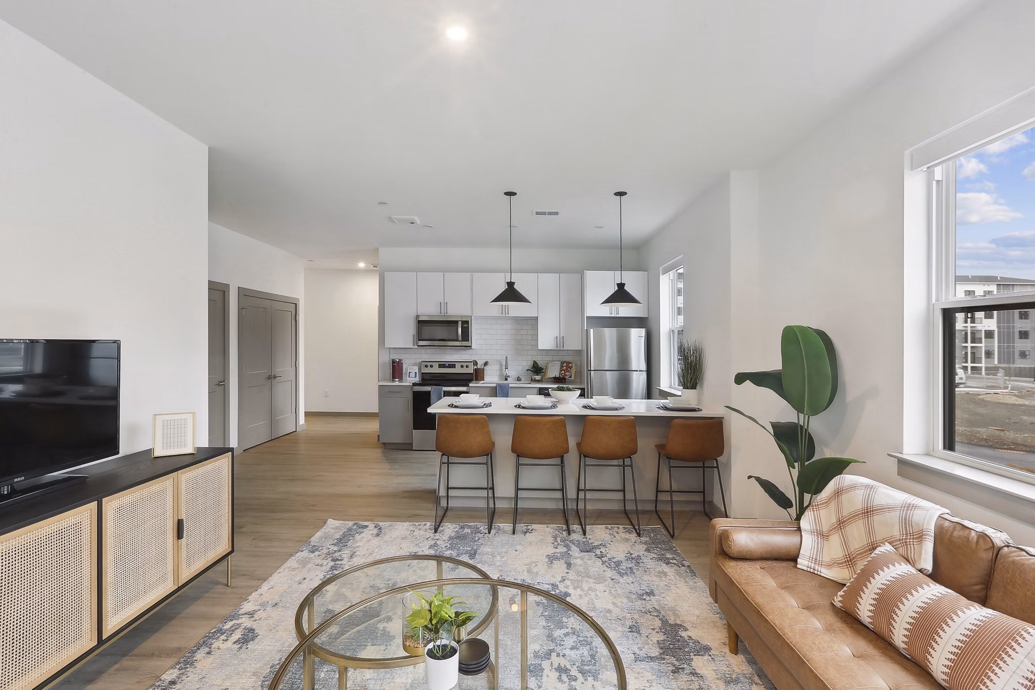 Cozy living room with stylish decor and a large window at The Foundmore Apartments