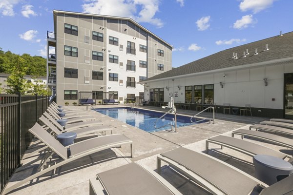 Outdoor pool with sun loungers at The Foundmore Apartments