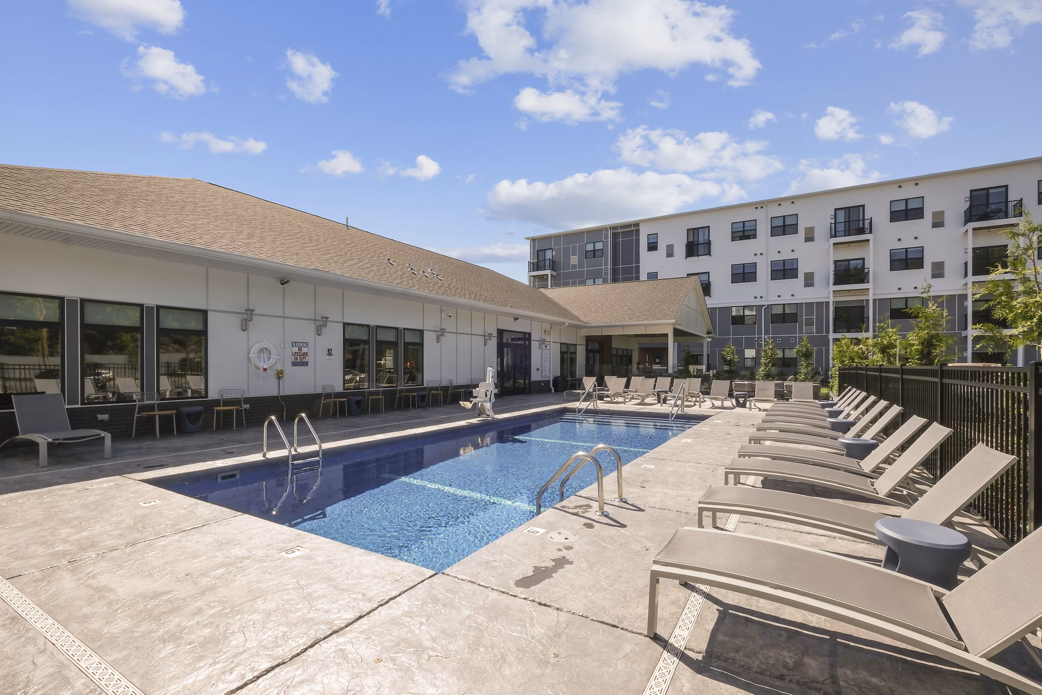 Resort-style pool surrounded by lush landscaping at The Foundmore Apartments offering luxury living