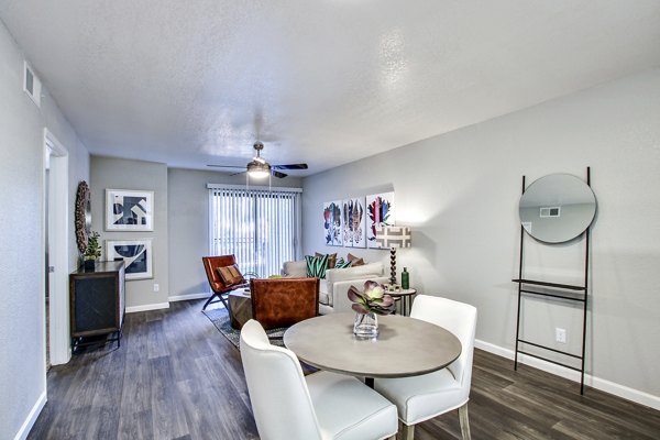 Modern living and dining area featuring a round table and artwork in luxury apartment