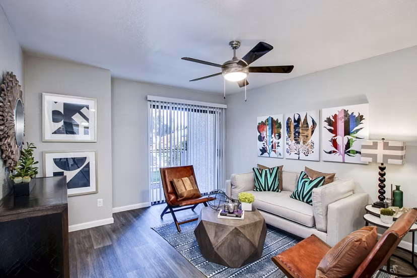 Modern living room featuring a ceiling fan, stylish sofa, and decorative plants in luxury apartments