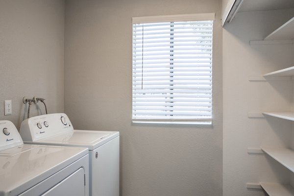 Laundry room with modern appliances at The Julia Apartments, a luxury Greystar property, featuring energy-efficient washers and dryers