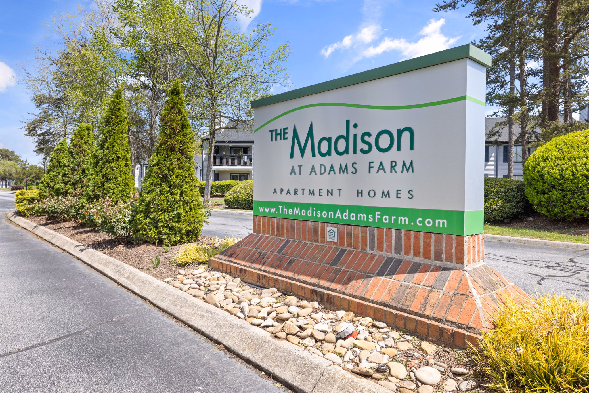 Madison at Adams Farm: Signage at the of luxury apartments near lush landscapes in Greensboro