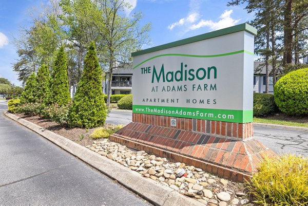 Madison at Adams Farm: Signage at the of luxury apartments near lush landscapes in Greensboro
