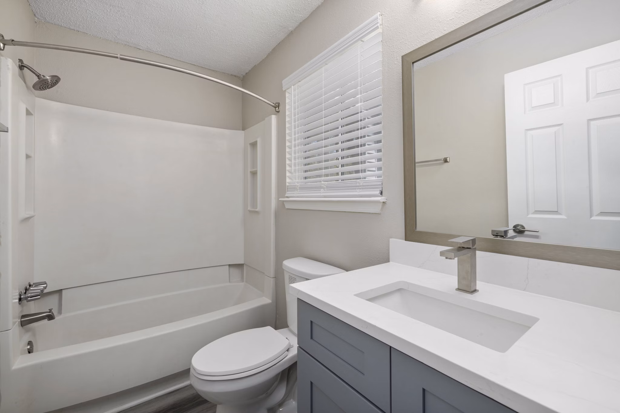 Modern bathroom with sleek vanity and large mirror at Madison at Adams Farm Apartments