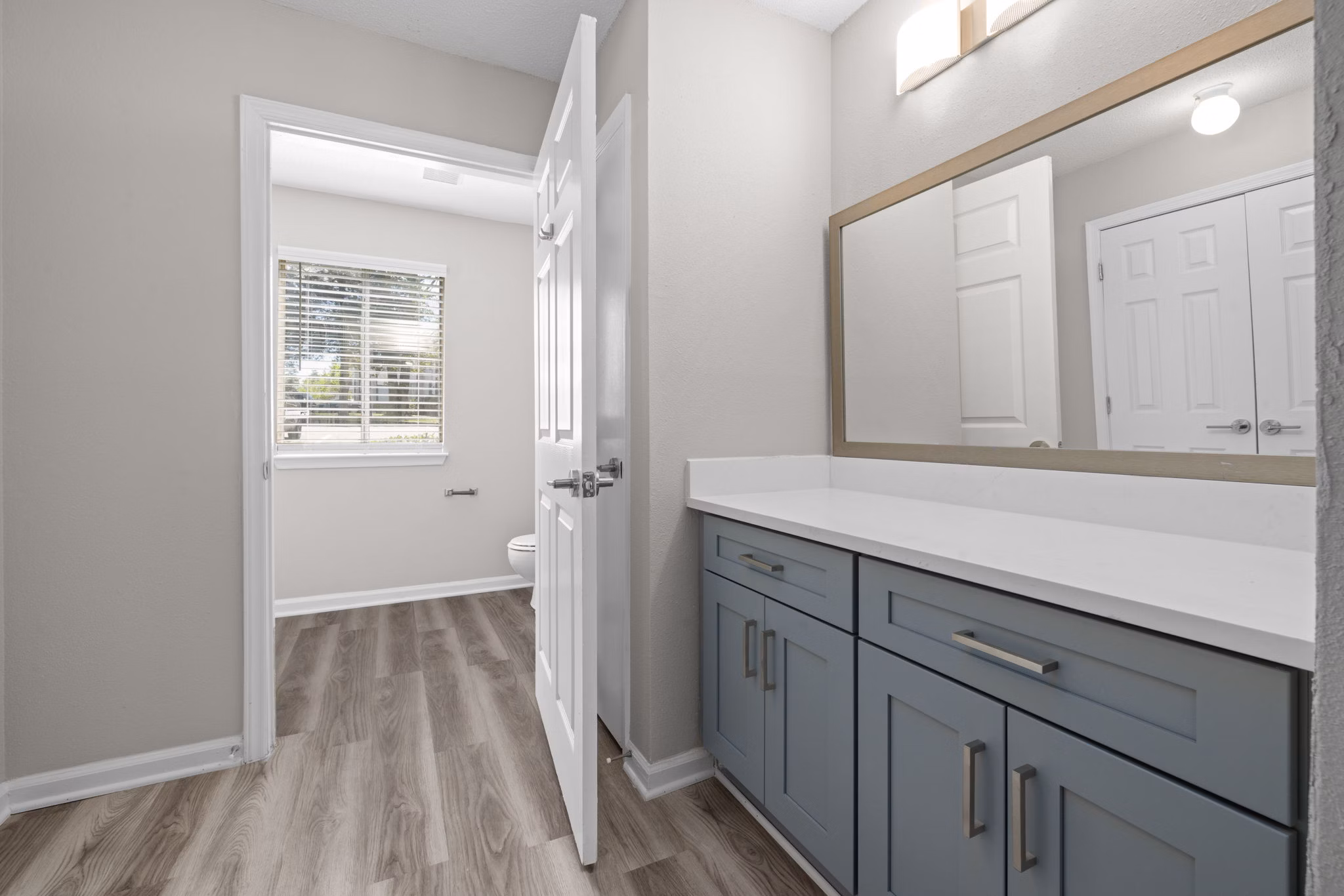 Elegant bathroom with modern fixtures at Madison at Adams Farm Apartments, featuring sleek countertops and large mirrors for a luxurious experience