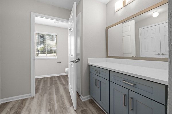 Elegant bathroom with modern fixtures at Madison at Adams Farm Apartments, featuring sleek countertops and large mirrors for a luxurious experience