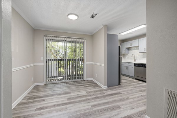 Dining area featuring elegant wooden dining set at Madison at Adams Farm Apartments, highlighting luxury living in a serene environment