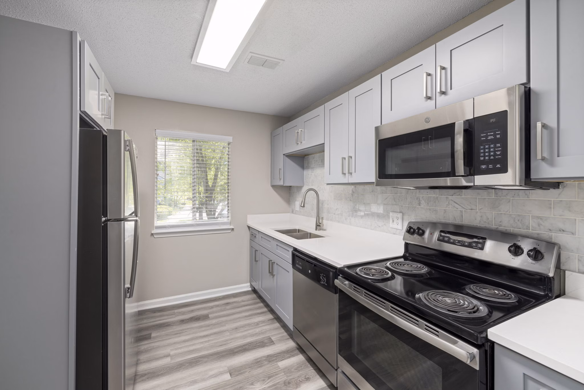Modern kitchen with stainless steel appliances in Madison at Adams Farm Apartments