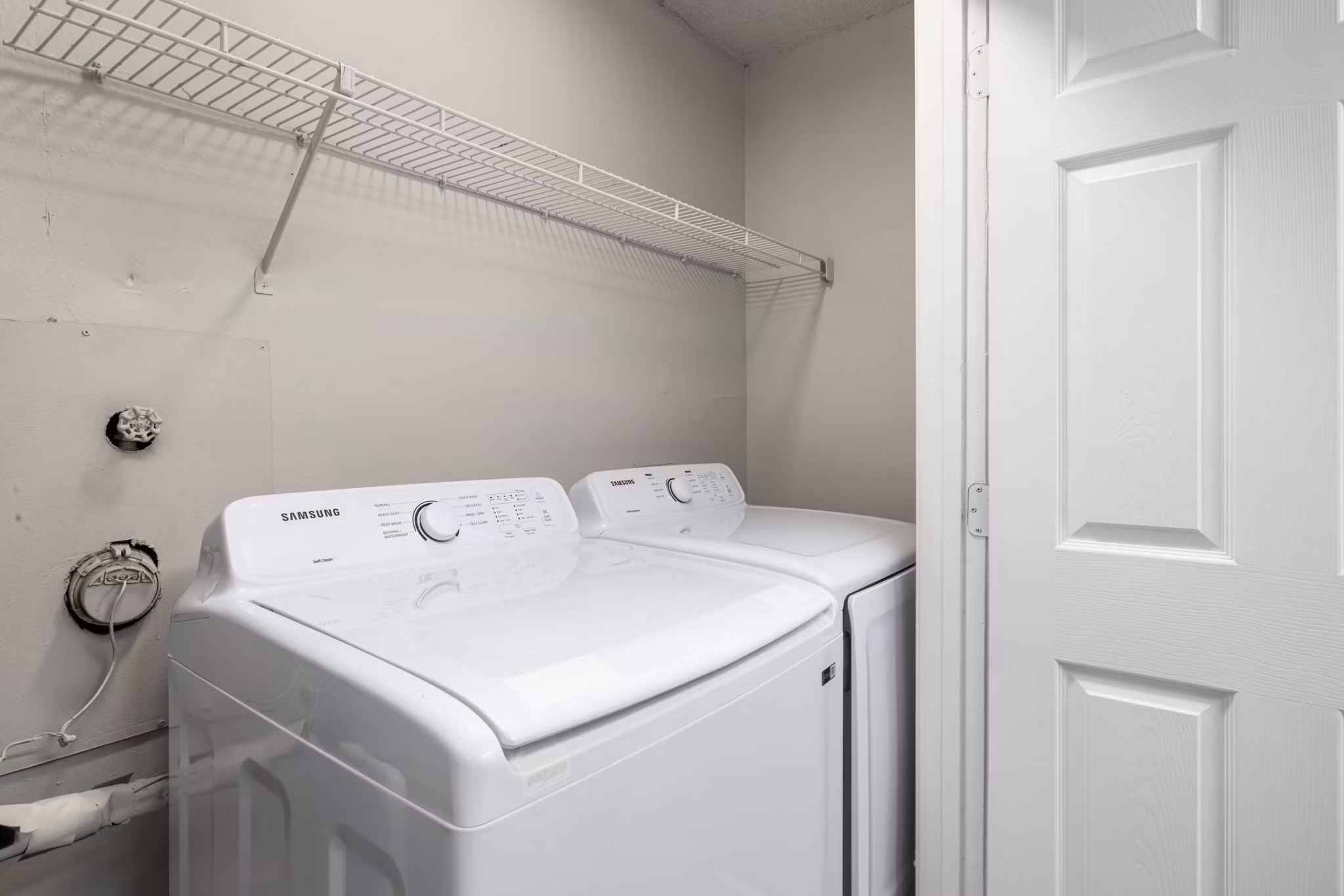 Laundry room with high-efficiency washer and dryer in Drexler Townhomes at Holbrook Farms