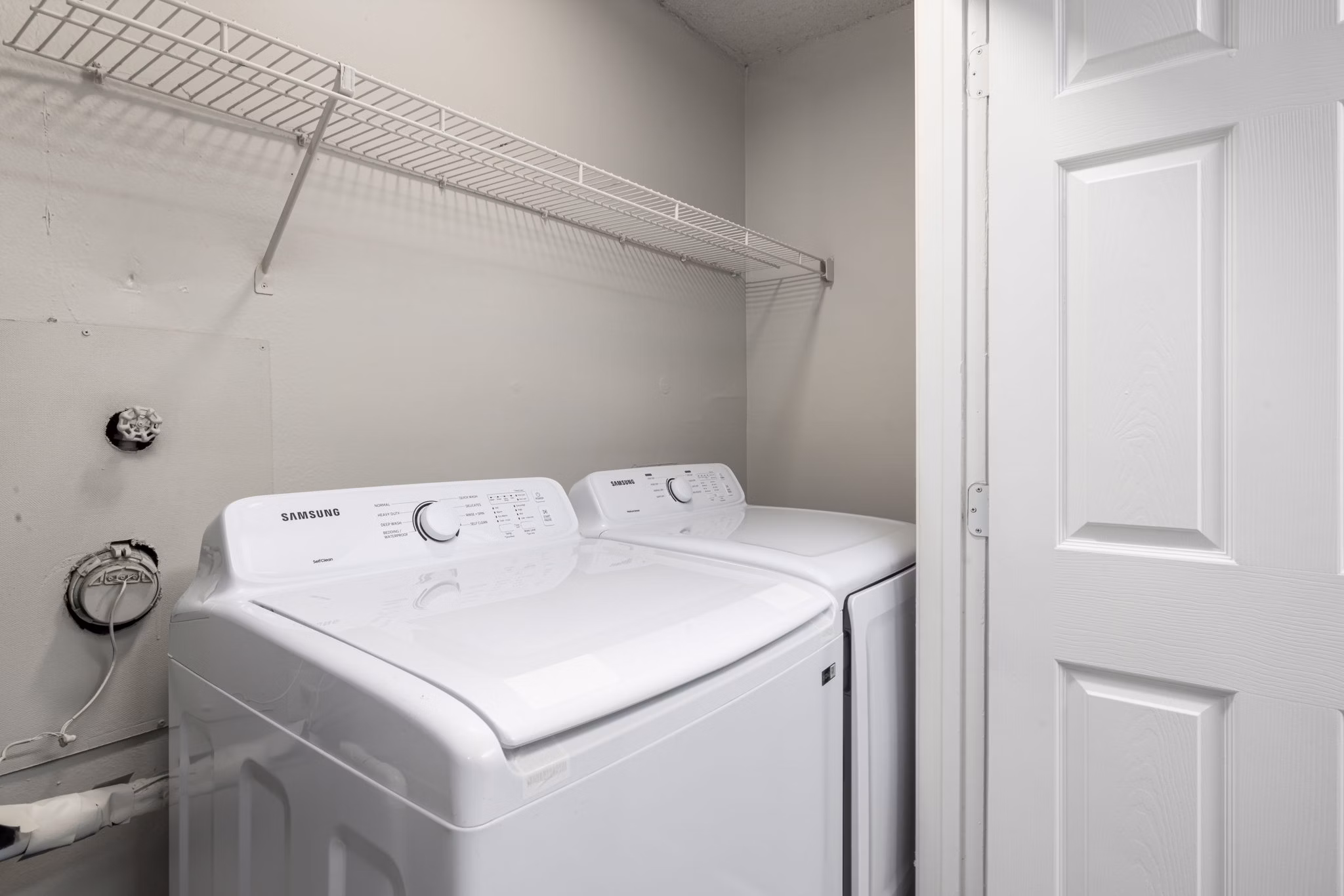 Laundry room with high-efficiency washer and dryer in Drexler Townhomes at Holbrook Farms