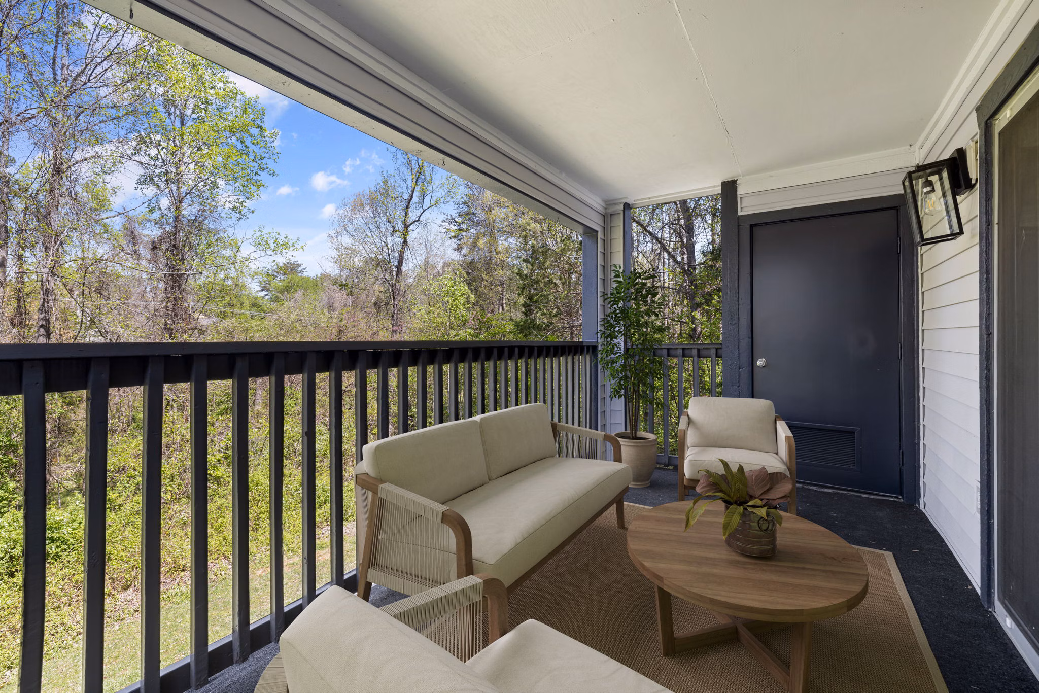 Outdoor patio with cozy seating and garden at Madison at Adams Farm Apartments