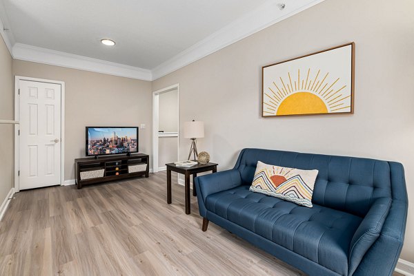 Modern living room with cozy seating and large windows at Mariners Crossing Apartments