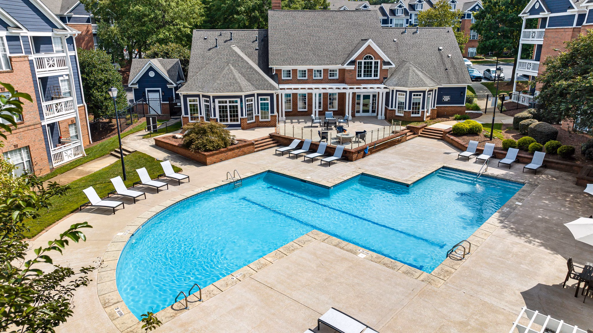 Relaxing pool at Mariners Crossing Apartments with lush landscaping and poolside seating
