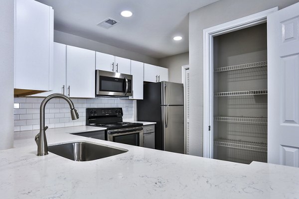 Kitchens with stainless steel appliances and granite countertops at The Quarry Alamo Heights Apartments