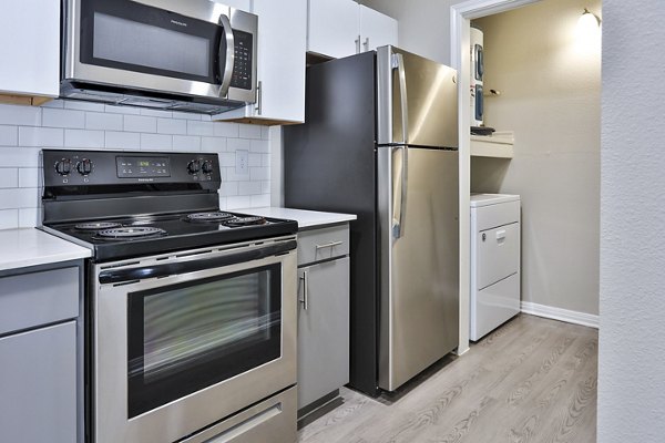 Kitchens and laundry rooms in The Quarry Alamo Heights Apartments offer modern appliances and sleek cabinetry