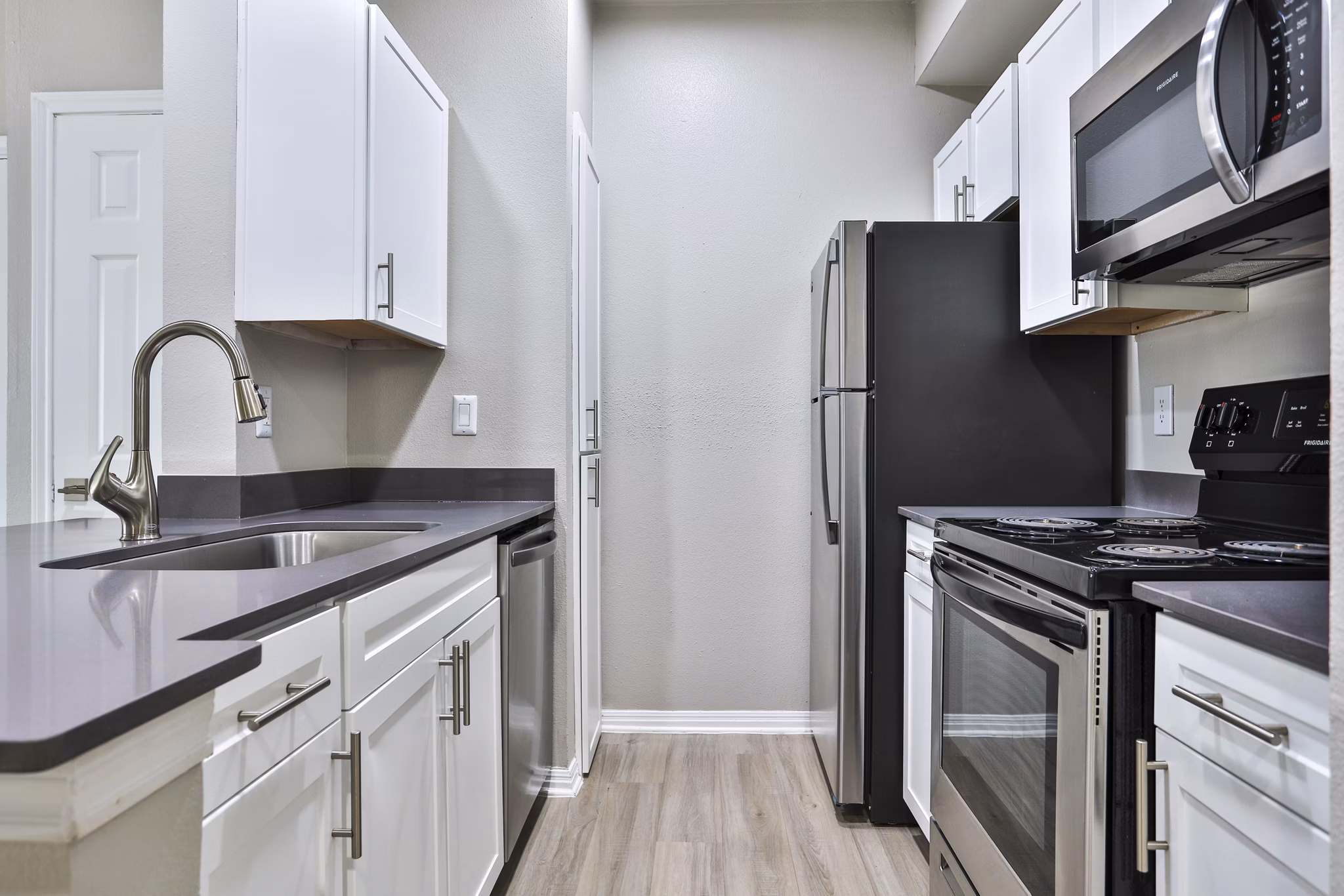 Modern kitchen with stainless steel appliances and marble countertops at The Quarry Alamo Heights Apartments