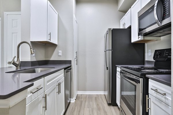 Modern kitchen with stainless steel appliances and marble countertops at The Quarry Alamo Heights Apartments