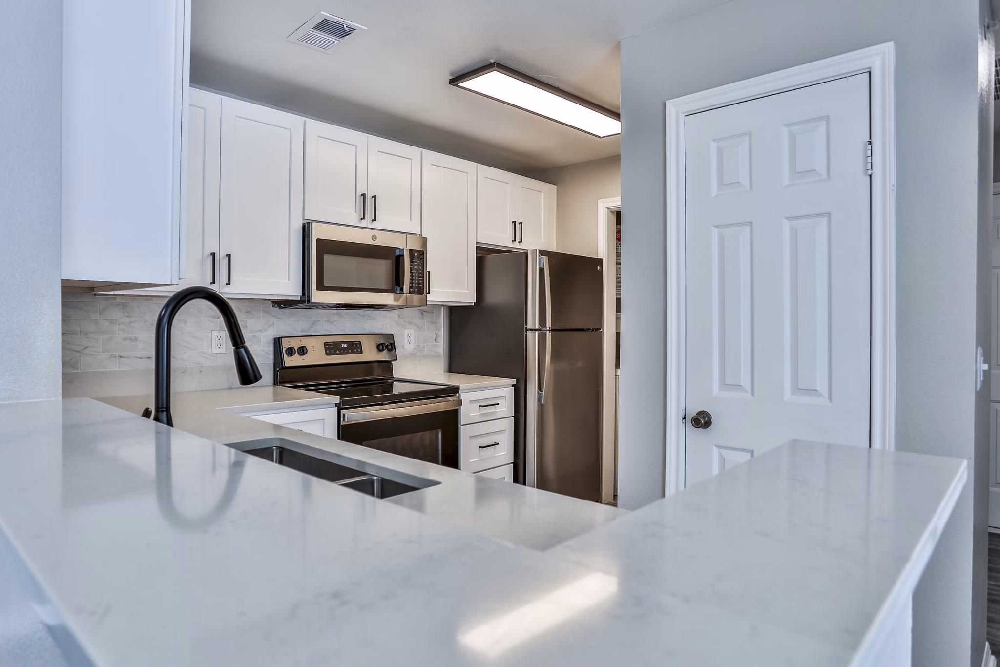 Modern kitchen with sleek countertops and stainless steel appliances at The Quarry Alamo Heights Apartments, San Antonio