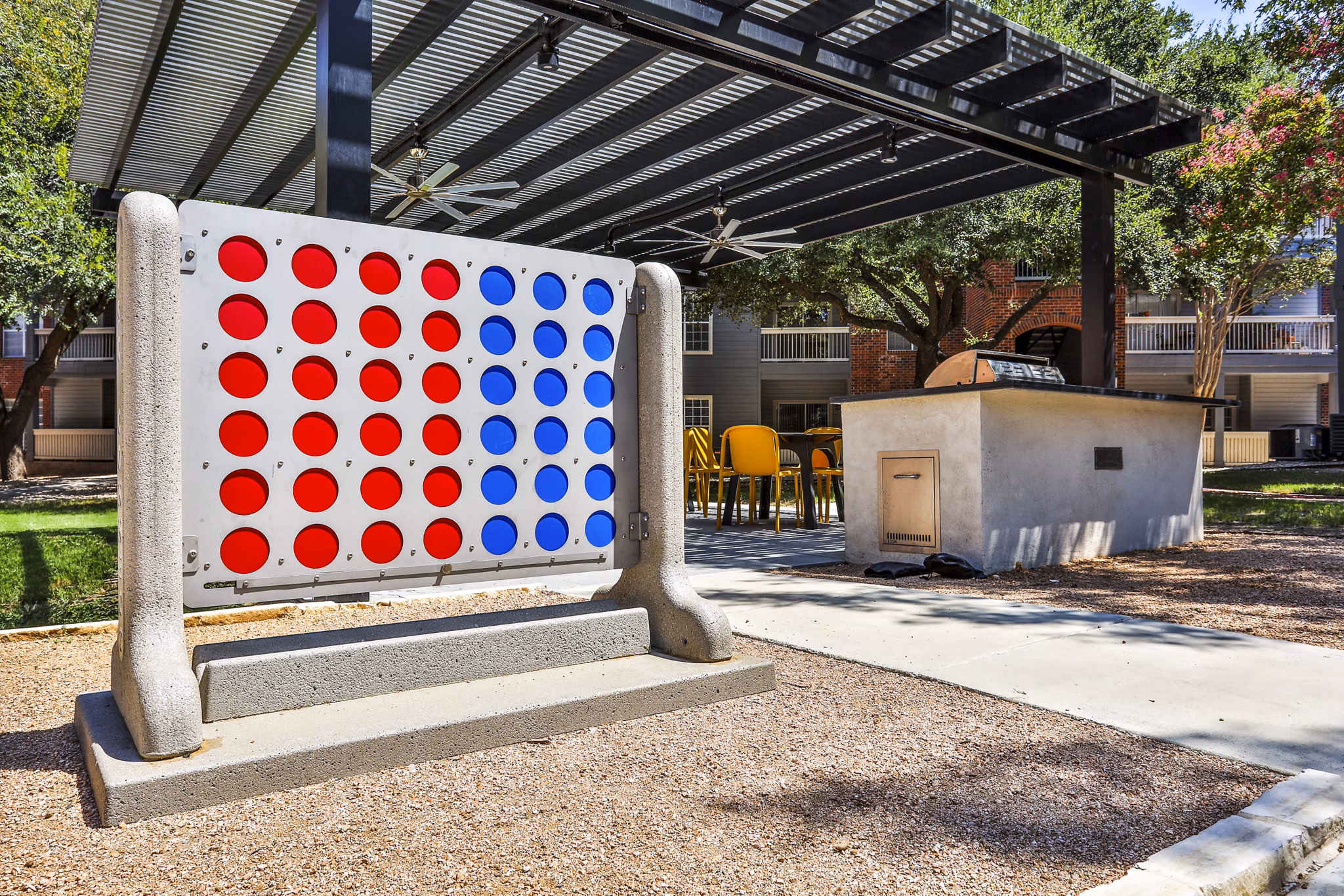 Outdoor grill area and patio at The Quarry Alamo Heights Apartments offering a recreational space in a luxurious setting