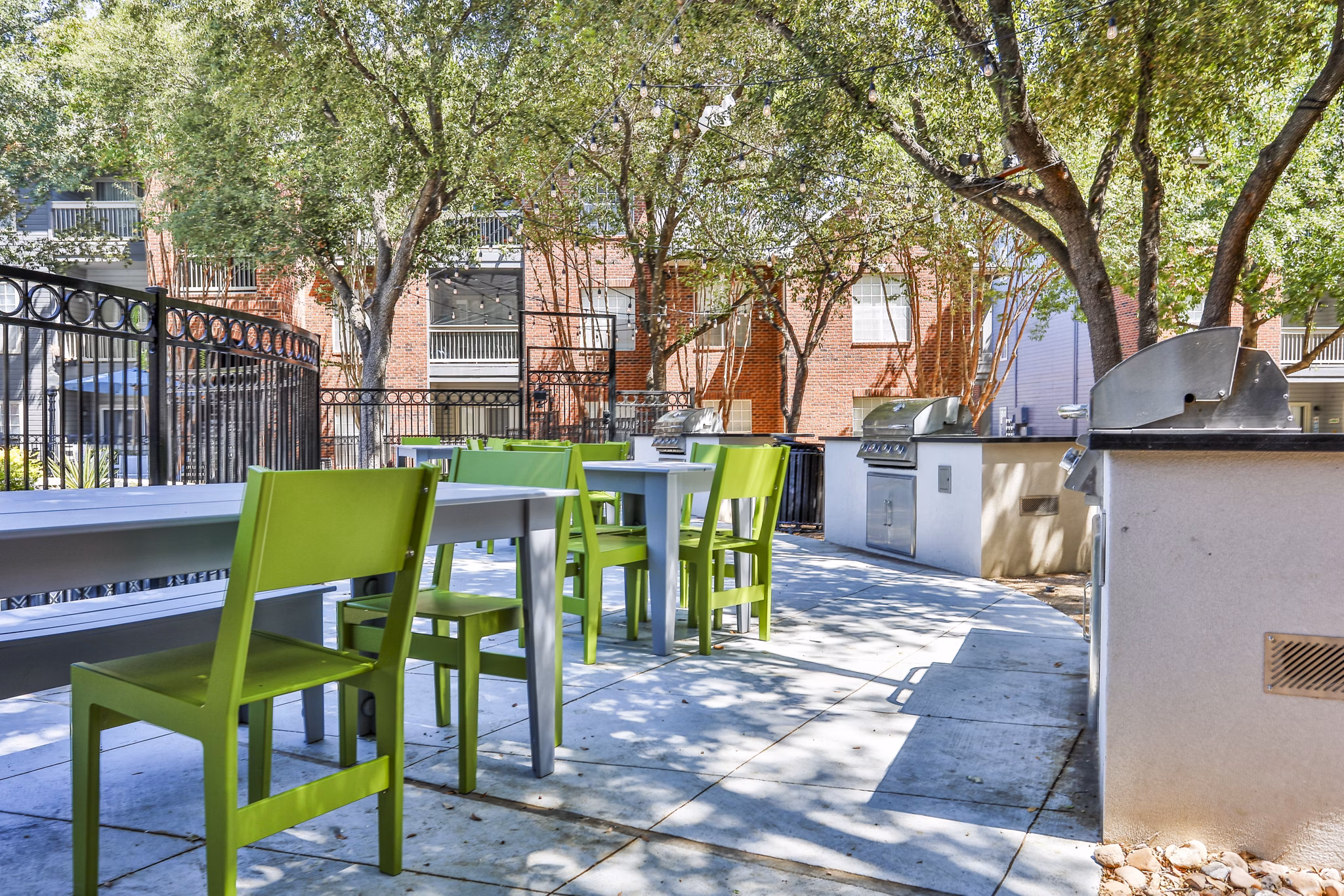 Outdoor grill area with seating at The Quarry Alamo Heights Apartments, perfect for social gatherings and BBQs