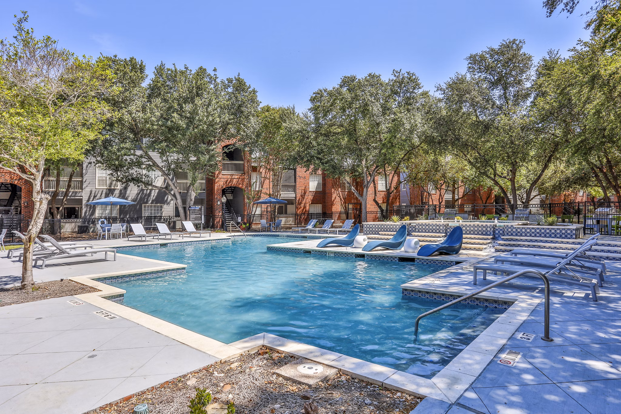 Resort-style pool with lounge chairs at The Quarry Alamo Heights Apartments