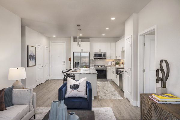 Living room featuring modern furniture and natural light at Alexan Montview Plaza Apartments