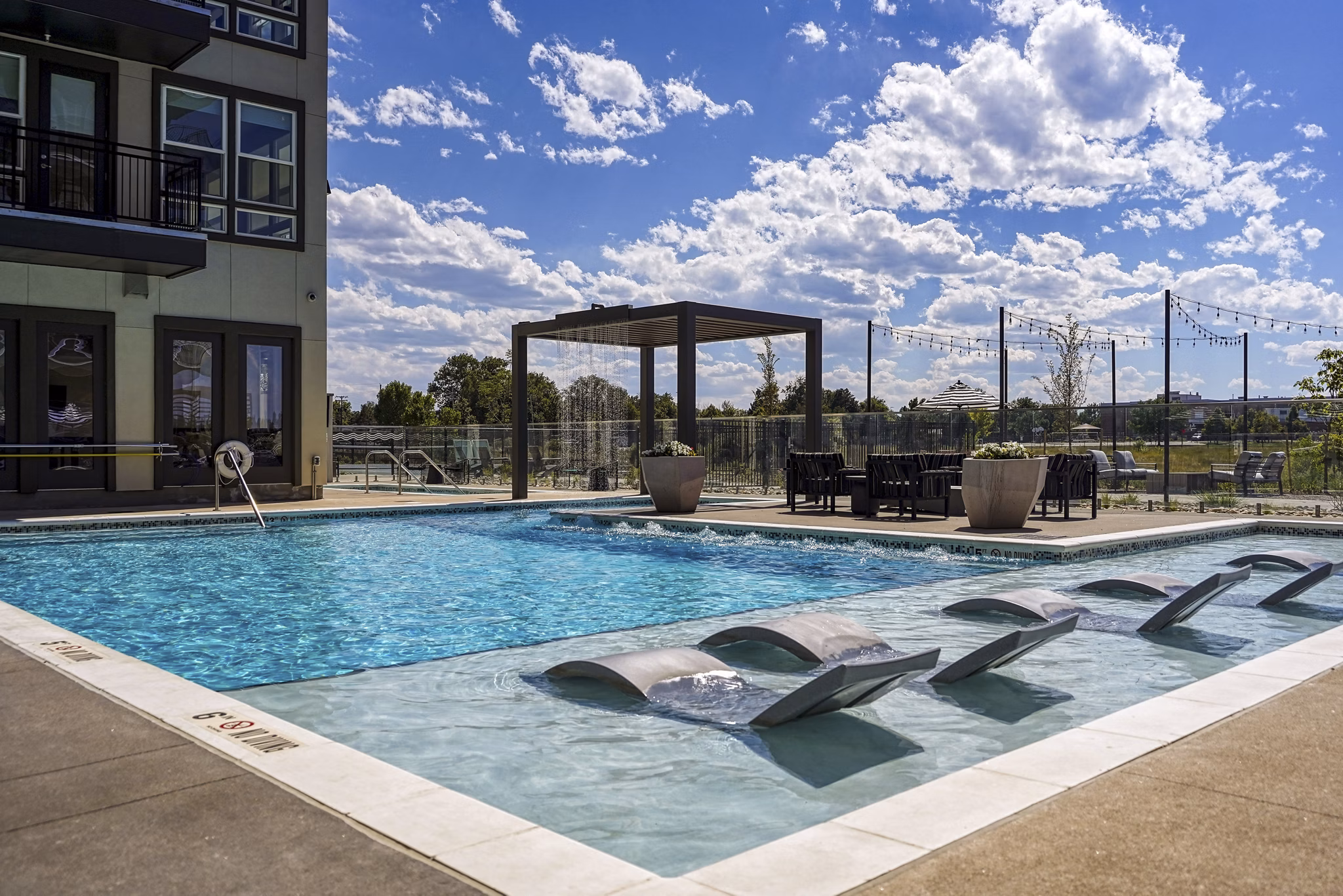 Luxurious pool with sun loungers at Alexan Montview Plaza Apartments, ideal for relaxation and leisure activities