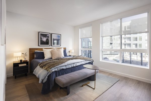 Cozy modern bedroom with plush bedding in Forge Apartments, offering luxury living in the heart of the city