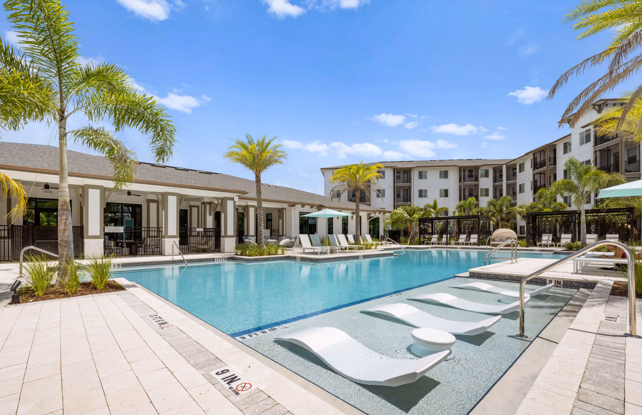 Marlowe Gateway Apartments: Lush outdoor pool area with modern lounge chairs