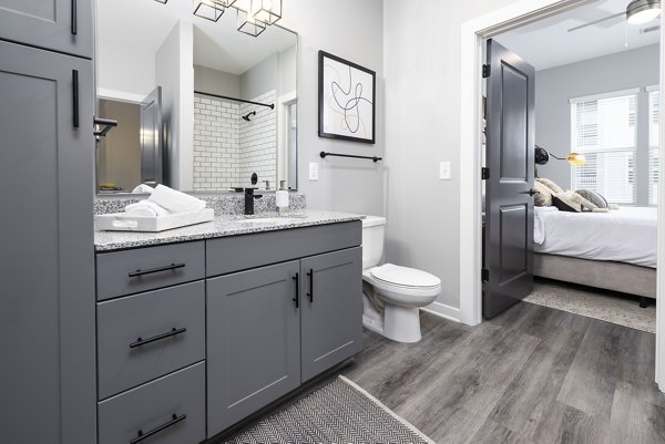 Luxurious bathroom featuring marble countertops and elegant fixtures in Apex Marathon Village Apartments