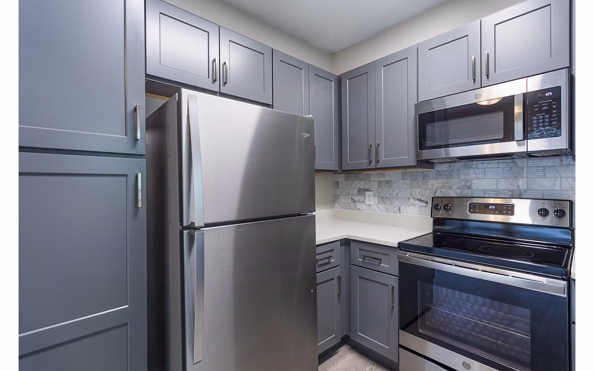 Sleek kitchen with stainless steel appliances and granite countertops in Ashton Brook Apartments